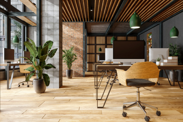 A modern office space filled with plants, desks, and natural light